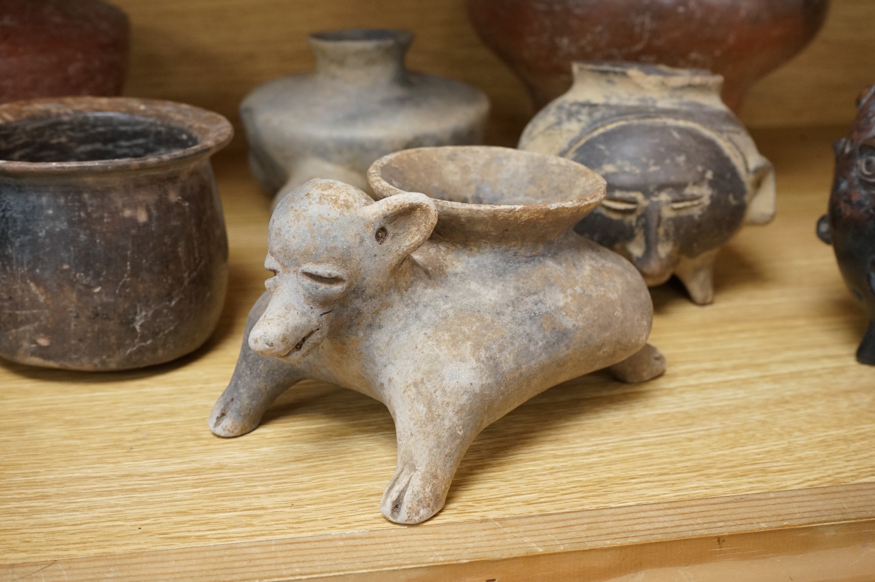 A collection of various South American vessels some in the form of grotesque heads, largest 24cm wide